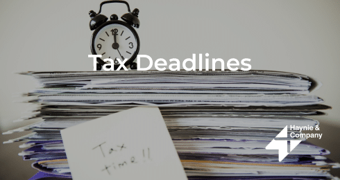 Stack of documents with a clock on top labeled Tax Deadlines from Haynie.