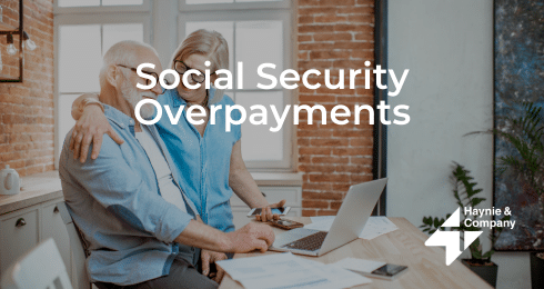 Senior couple discussing social security overpayments with a laptop at home.