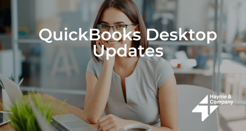Businesswoman working on laptop, smiling. QuickBooks Desktop Updates by Haynie.