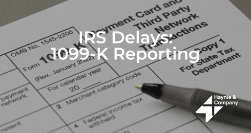 IRS Delays 1099-K Reporting Concept with Form and Pen.