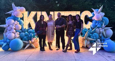 Group of people at a Haynie event with balloon decorations and KINETIC sign.
