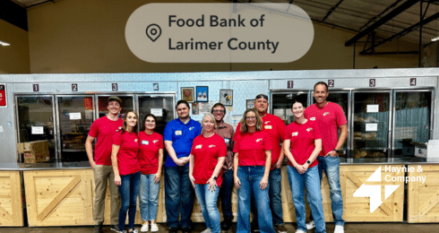 Group of people volunteering at the Food Bank of Larimer County with Haynie logo.