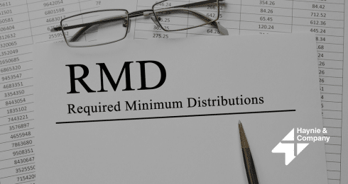 RMD document on Required Minimum Distributions with glasses and pen, from Haynie.