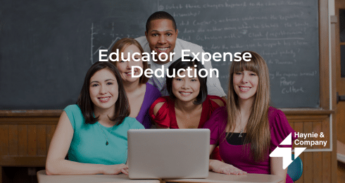 Educators gathered around a laptop, discussing expense deductions.