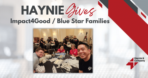 Haynie Gives event with people gathered around a table, Impact4Good, Blue Star Families logo in background.