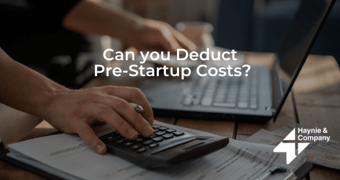Person using calculator and laptop with text Can you Deduct Pre-Startup Costs? by Haynie.
