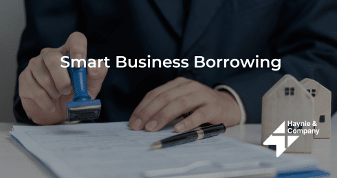 Businessperson stamping documents, Smart Business Borrowing, Haynie logo.