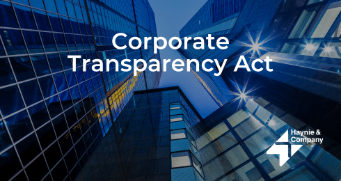 Corporate Transparency Act text over modern glass office buildings at dusk with Haynie logo.