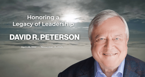 Honoring David R. Peterson's legacy with a smiling portrait against a cloudy sky background.