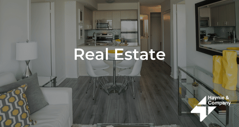 Modern kitchen and dining area with sleek decor and neutral colors, labeled Real Estate by Haynie.