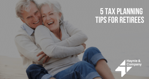 Older couple embracing and smiling on a beach with 5 Tax Planning Tips for Retirees text overlay.
