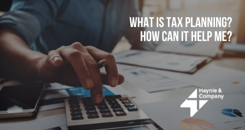 Person using calculator for tax planning, Haynie logo visible.