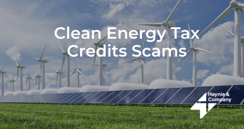 Clean energy tax credits scams text on image of wind turbines and solar panels under a blue sky.