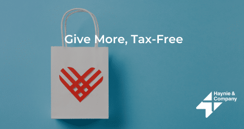 Shopping bag with heart logo, text: Give More, Tax-Free, Haynie logo on blue background.