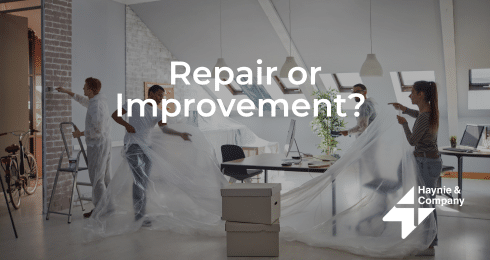 Workers preparing office for renovation with plastic sheeting, question Repair or Improvement? displayed.