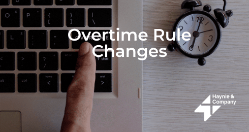 Overtime Rule Changes text with a finger pressing a laptop key and a clock nearby.