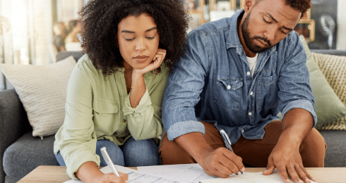 A couple reviewing documents at a table, focused on decision-making at home.