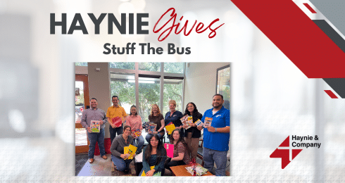 Haynie team posing with donations for the Stuff The Bus charity event.
