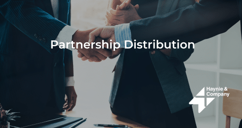 Two people in business suits shaking hands over a table, with Partnership Distribution text.