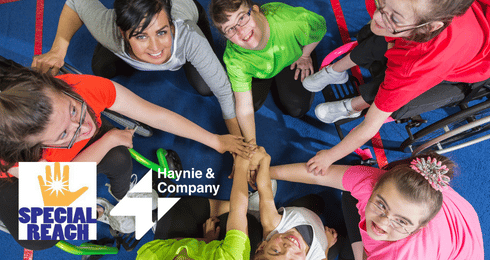 Group of people in a circle, joining hands with Special Reach and Haynie logos.