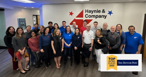 Group photo of Haynie employees in office, with 2023 Top Workplace award from The Denver Post.