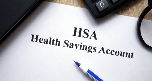HSA Health Savings Account document with pen and calculator on a desk.
