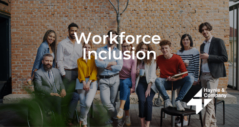 Diverse group of professionals promoting workforce inclusion, standing and sitting against a brick wall background.