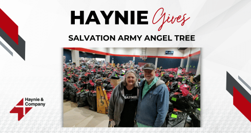 Haynie event with two people at Salvation Army Angel Tree, surrounded by gift bags.