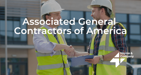 Two construction workers shaking hands, wearing helmets and vests, logo of Associated General Contractors of America.