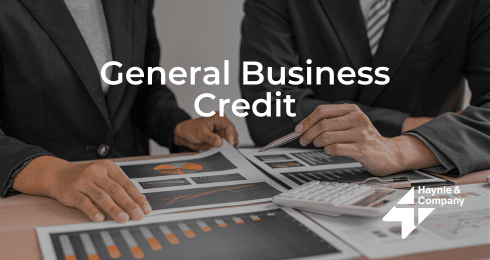 Business professionals analyzing charts and graphs with General Business Credit text overlay.