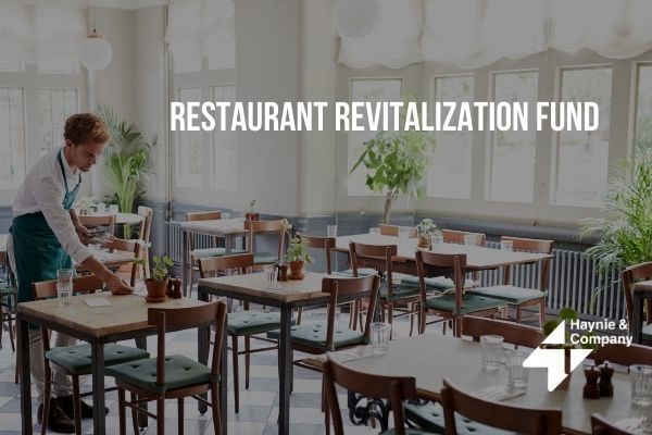 Restaurant worker setting tables, promoting revitalization fund.