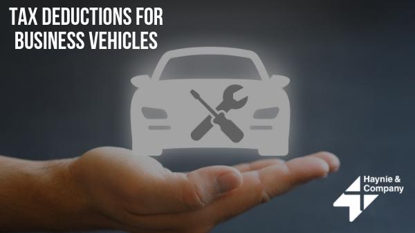 Tax deductions for business vehicles concept with car icon over hand and Haynie logo.