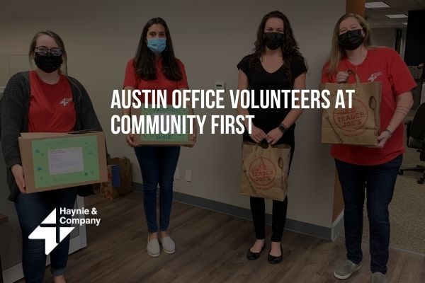 Haynie volunteers in Austin office holding donation boxes and bags at Community First event.