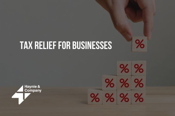 Hand stacking percentage blocks; text reads Tax Relief for Businesses, Haynie logo visible.