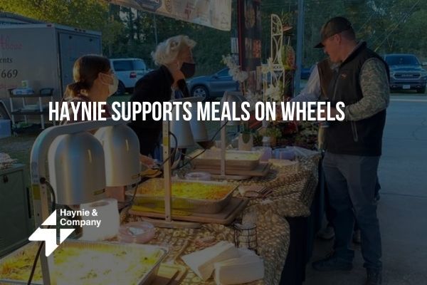 Haynie event supporting Meals on Wheels, featuring a food stand with attendees outdoors.