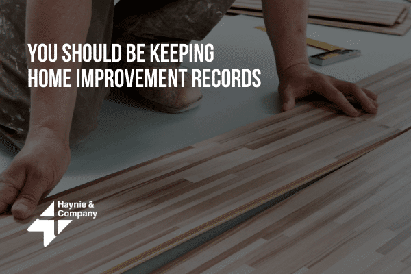 Person installing wooden floorboards; text: You Should Be Keeping Home Improvement Records. Haynie logo.