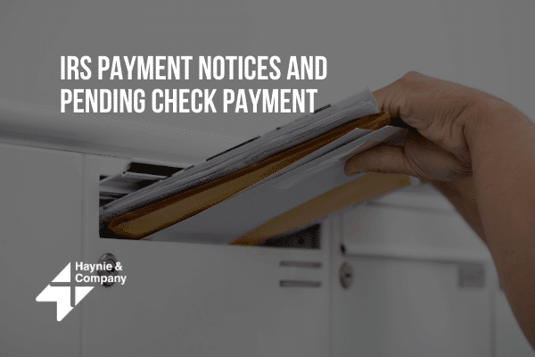 IRS payment notice in hand at mailbox with Haynie logo.