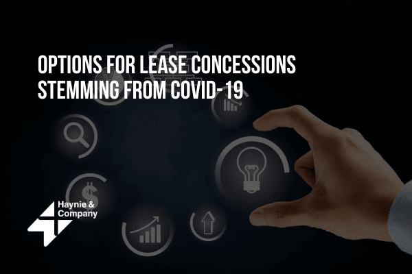 Hand selecting finance icons on interactive screen about COVID-19 lease concessions with Haynie logo.