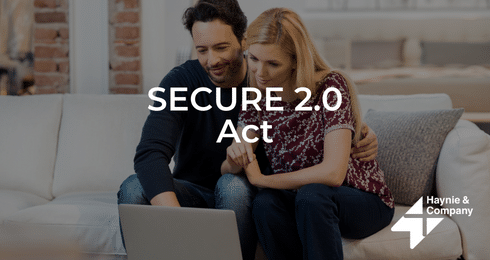 Couple reviewing SECURE 2.0 Act on laptop in a cozy living room.