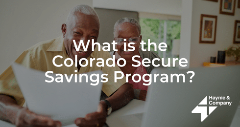 Elderly couple smiling while reviewing papers about Colorado Secure Savings Program.