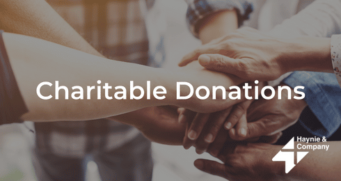 Group of hands joined together with the text Charitable Donations and Haynie logo.