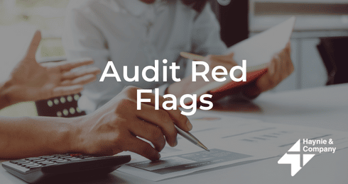 Audit Red Flags presentation with a person holding a pen and a calculator on the table.
