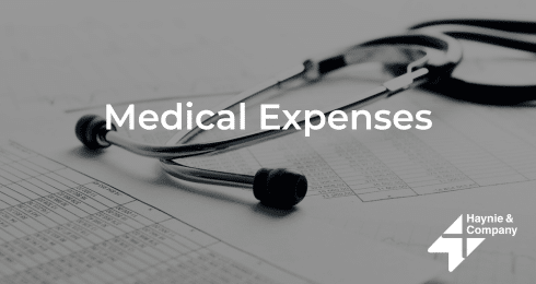 Medical expenses concept with a stethoscope and financial documents, Haynie.