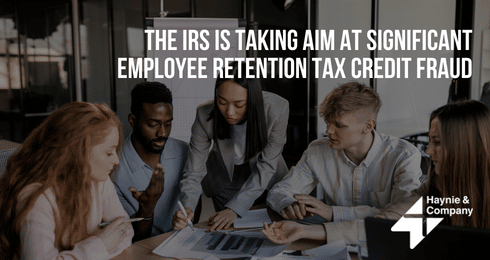 Group of professionals discussing IRS employee retention tax credit fraud policy. Haynie logo visible.