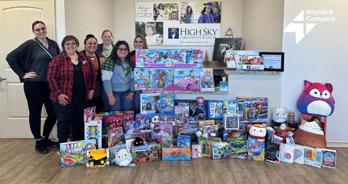 Group of people with donated toys at High Sky Children's Ranch.