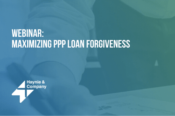 Webinar on maximizing PPP loan forgiveness by Haynie with a close-up of a person writing.