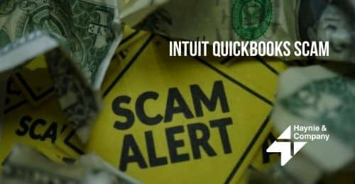 Intuit QuickBooks scam alert sign surrounded by dollar bills.