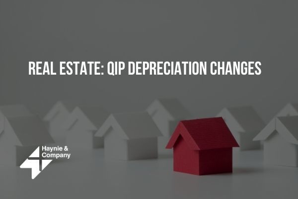 Real estate concept with red house model and text about QIP depreciation changes.