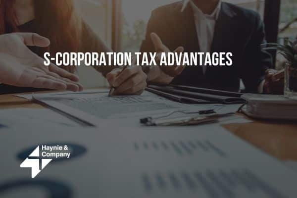 S-Corporation tax advantages discussion with documents and people at a table. Haynie logo visible.