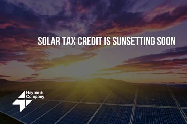 Sunset over solar panels with text Solar Tax Credit is Sunsetting Soon and Haynie logo.